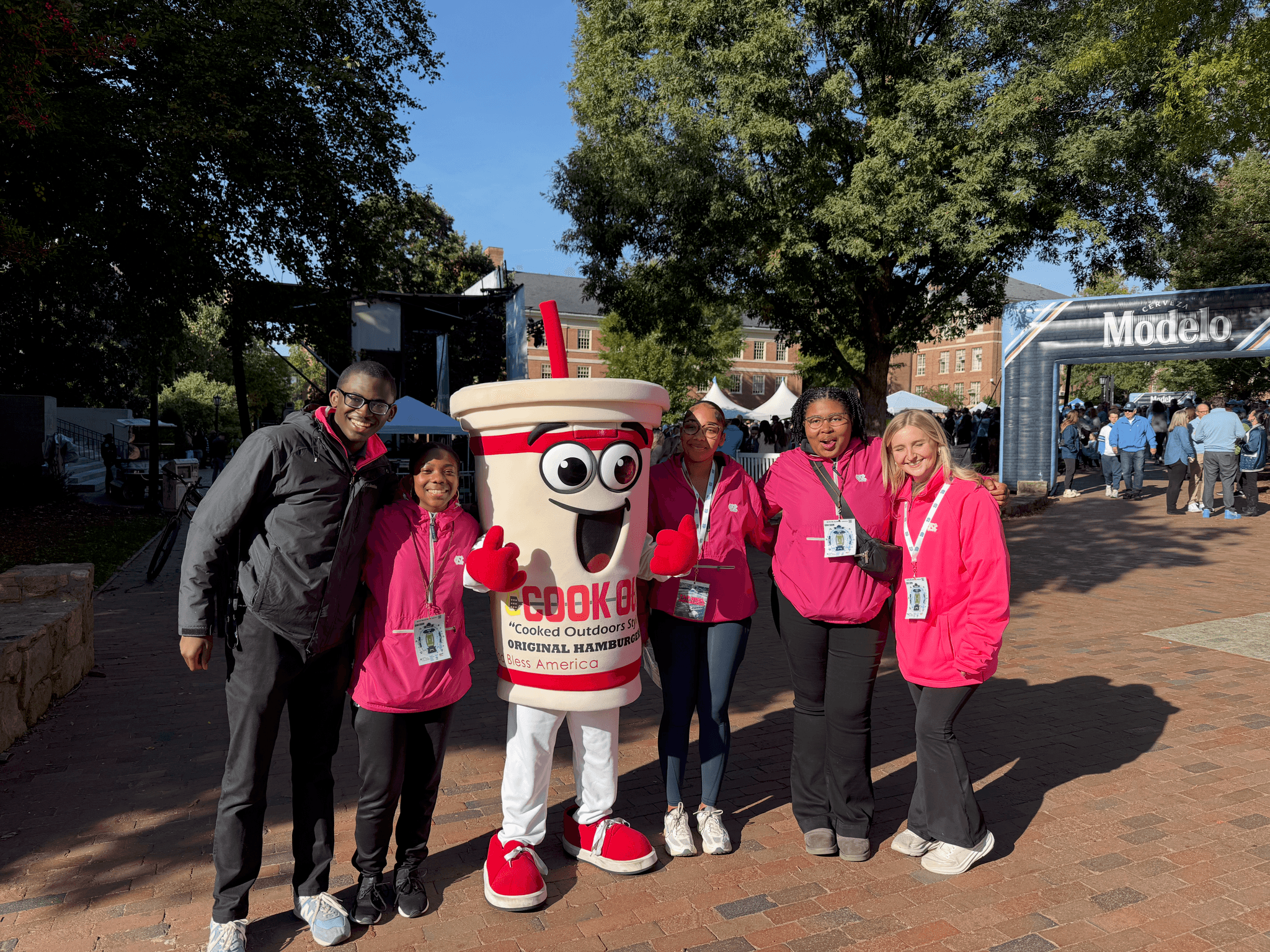 Devin smiling with an anthropomorphic Cookout mascot